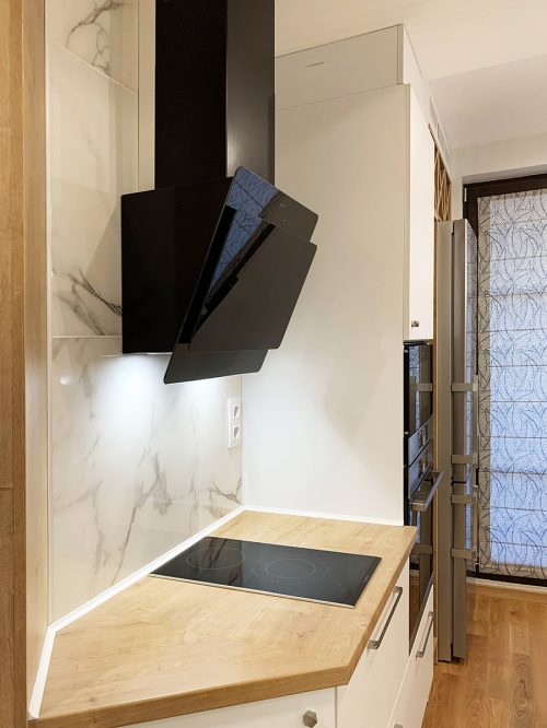 Черен аспиратор, бял мрамор и дървесен плот